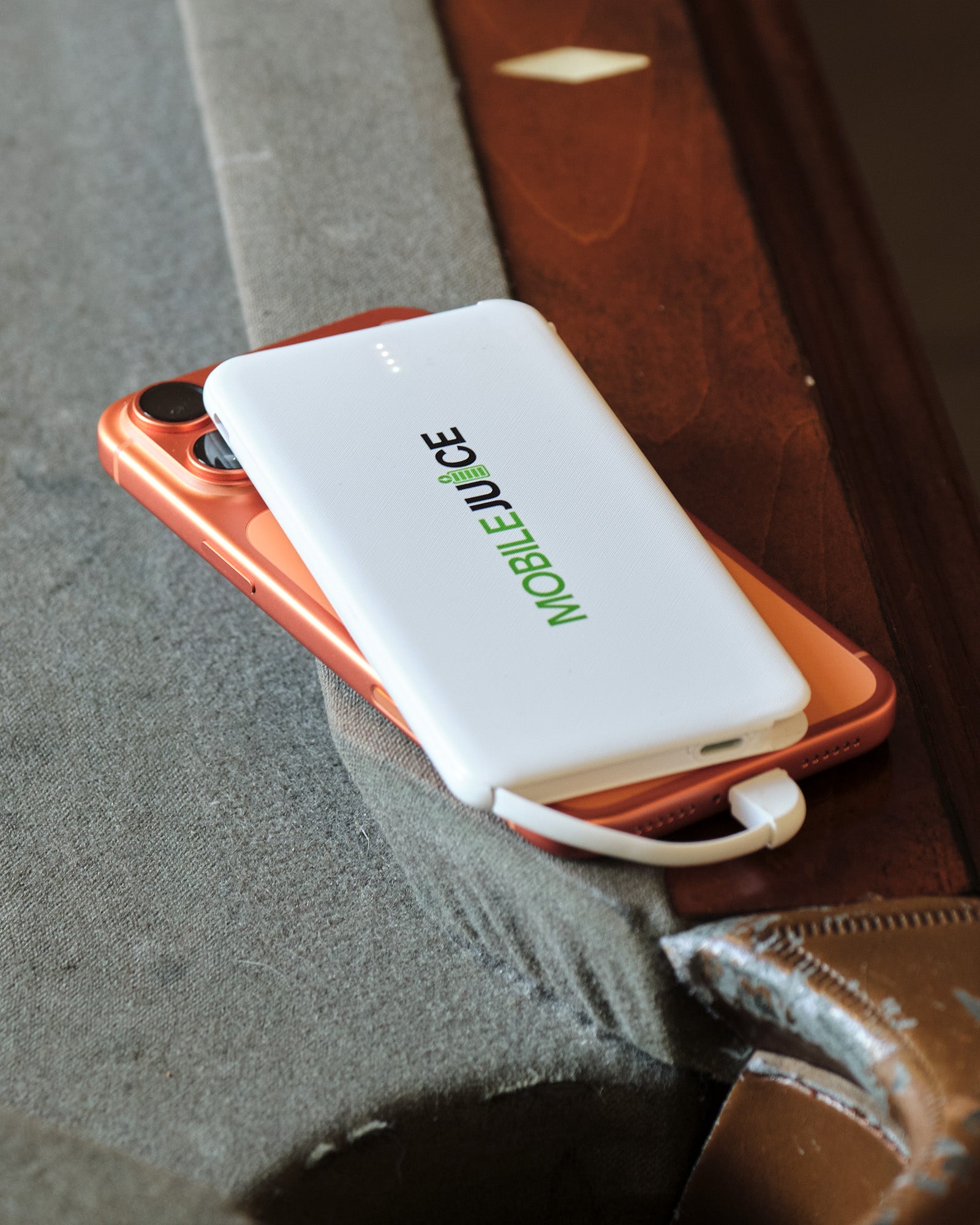 Phone with a power bank labeled 'Mobile Juice' on a textured surface