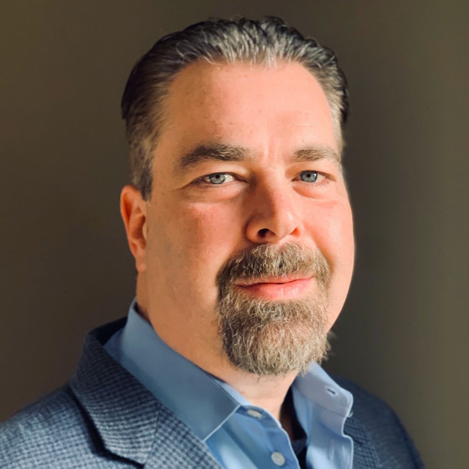 Man wearing a blue shirt against a neutral background