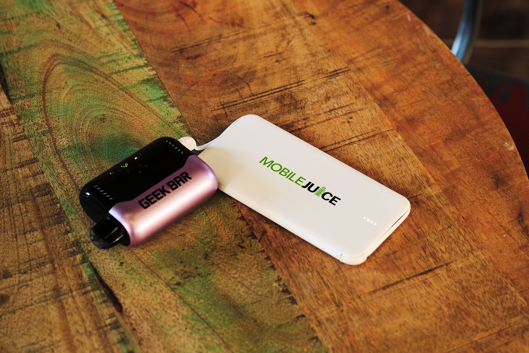 Small electronic device with 'Mobile Juice' branding on a wooden surface